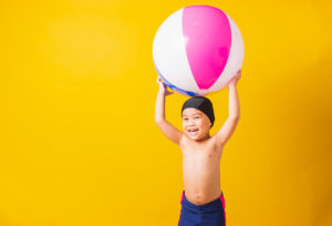 Child Boy Smiling In Swimsuit Hold Beach Ball